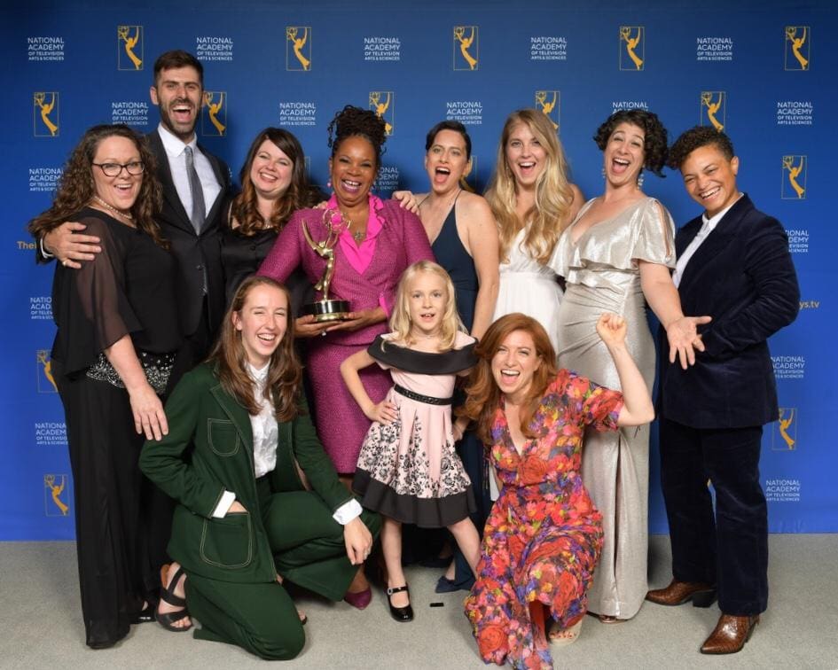 A group of people holding trophies and posing for the camera.