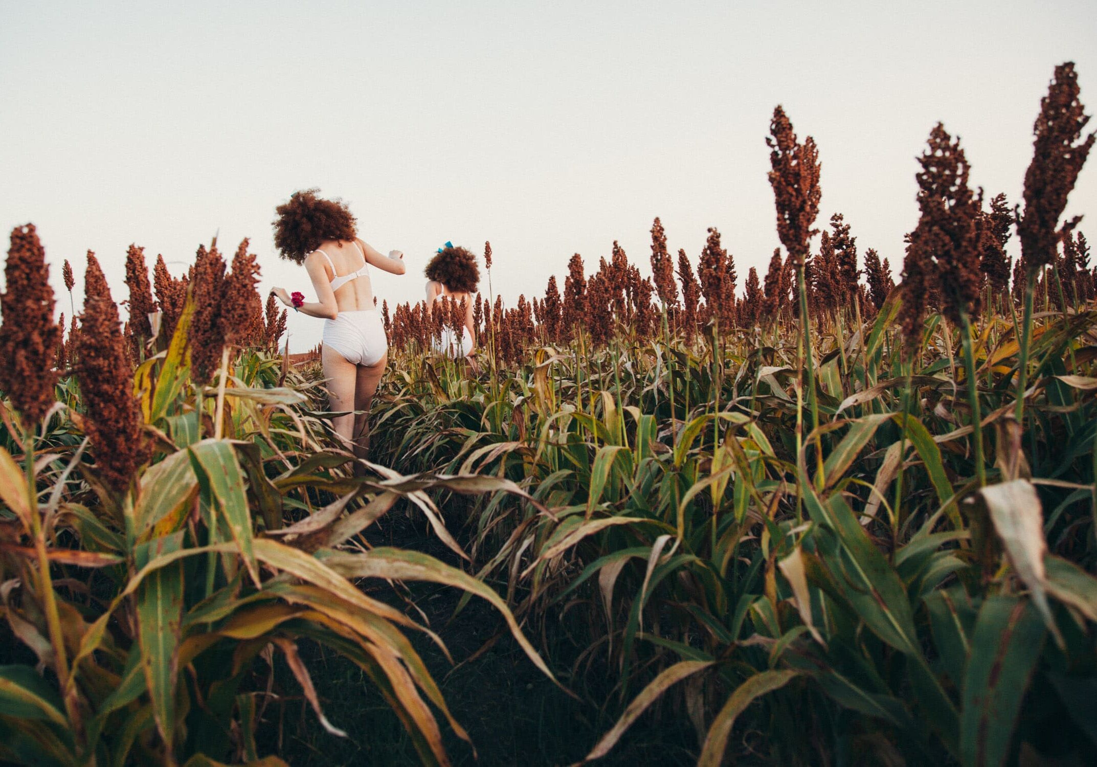 A woman running through the grass in a field.