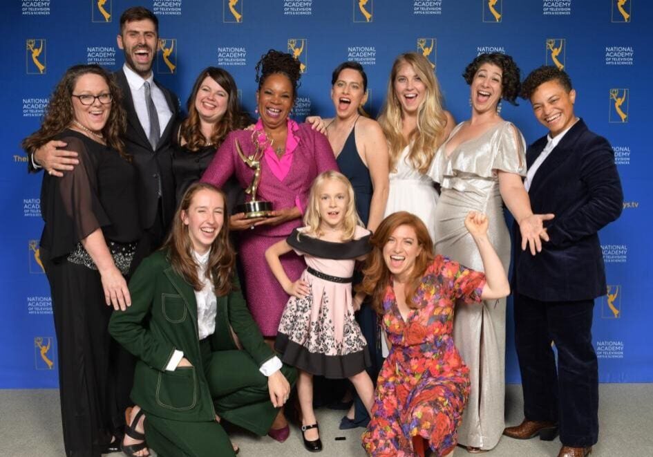 A group of people holding trophies and posing for the camera.